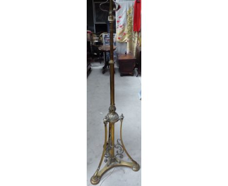 A Victorian brass Standard Lamp with adjustable column on scroll decorated triple supports and platform base. 