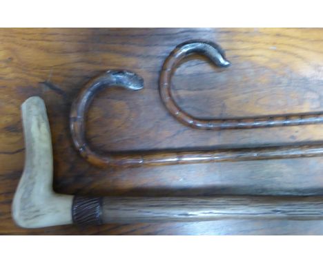 An early 20th century partridge wood Walking Stick with silver mounted crook handle, another, and a rustic stick with bone cr