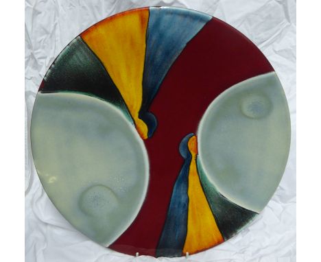 Another Poole Pottery Charger decorated with coloured segments in maroon, blue, yellow, black, etc., 16" (41cms) diameter.