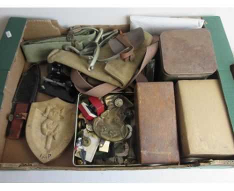 Mixed assortment of militaria, including buttons, cap badges, gas masks, a vintage throwing knife, spurs, a carved stone H.M.