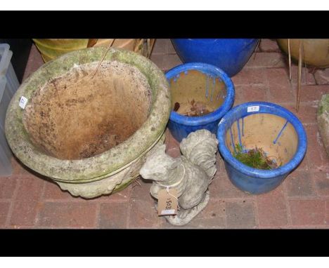 A circular garden plant pot, two small blue plant pots and a squirrel ornament 