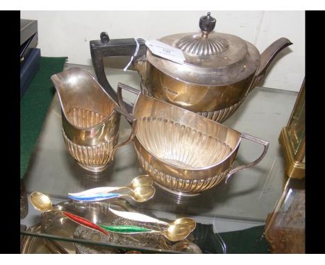 A three piece silver tea set together with enamel tea spoons