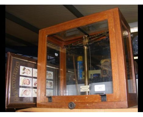 A set of laboratory scales, together with framed cigarette cards 
