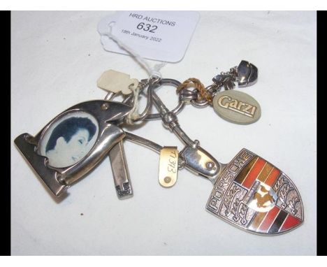 A silver Porsche keyring together with a 'photograph' keyring