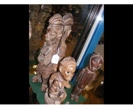 An old carved wooden African pair of tribal figures back-to-back - 40cm high, together with two smaller carved African tribal