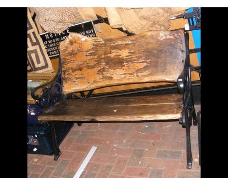 A rustic wrought iron and wooden garden bench 