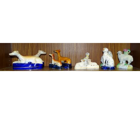 A collection of four Staffordshire ceramic greyhound pen holders, various sizes and other Staffordshire dog and sheep figures