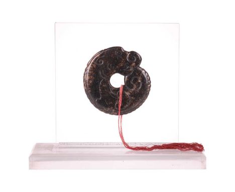 A Chinese archaistic carved brown/ black jade dragon pendant amulet thought to be Han Dynasty (206 BC- 220 AD), housed in a c