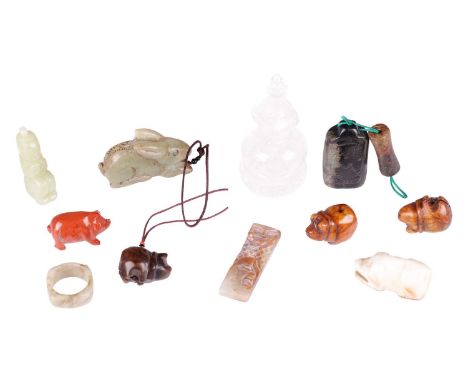 A small collection of Chinese carved jade items including a celadon jade archer's ring, a small red jade figure of a pig, and
