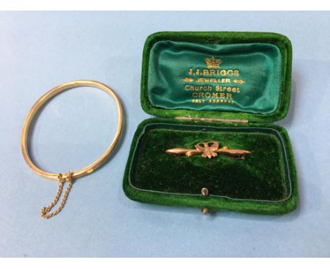 A bangle stamped '15', 5.5g and a 9ct brooch, 0.8g