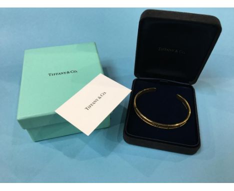 A Tiffany and Co. 18ct gold ‘Atlas Cuff’ bangle, stamped 750, dated 1995, weight 37.3 gram (boxed)