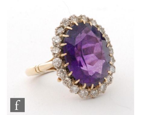 An 18ct amethyst and diamond cluster ring, central oval amethyst, length 16mm, within a border of twenty brilliant cut diamon