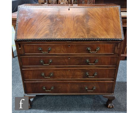 An Edwardian Chippendale style mahogany bureau, the fitted interior over four long drawers, on cabriole legs with claw and ba