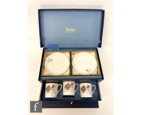 A 1950s boxed Shelley coffee set comprising six cups and saucers each decorated with a transfer applied ink floral spray, ret