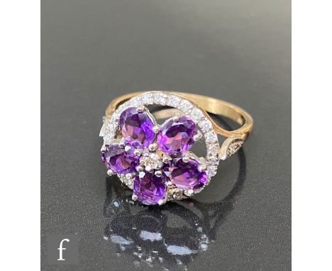 A 9ct hallmarked amethyst and diamond cluster ring, five oval claw set amethysts radiating from a central diamond, all within