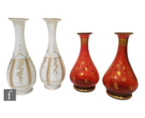 A pair of late 19th Century opaline glass vases of slender baluster form, enamelled in red and gilt decorated with branches, 