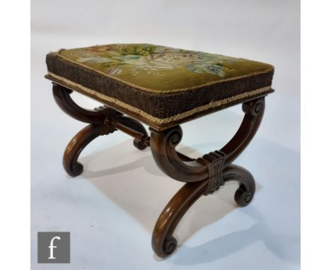 A Victorian rosewood stool on scroll cross frame, upholstered in floral tapestry on a green ground, width 57cm, S/D. 