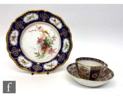 An early 19th Century Worcester tea cup and saucer decorated with bands of Kakiemon flowers between blue panels, unmarked, sa