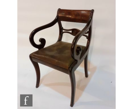 A George IV mahogany carver chair, with scroll arms above the leather upholstered drop-in seat panel and raised to sabre fron
