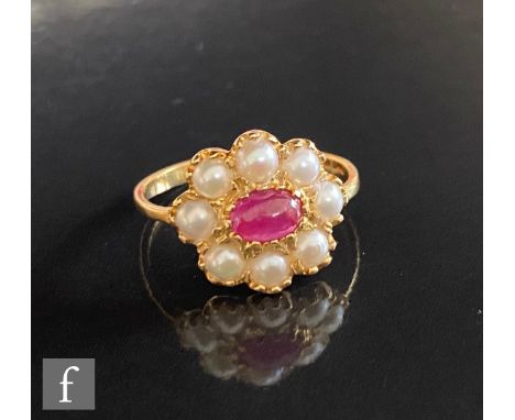 A 18ct hallmarked ruby and split pearl cluster ring, central oval ruby within a eight pearl surround, weight 2.5g, ring size 