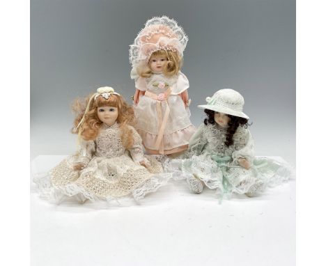 Beautiful porcelain dolls dressed in period clothing with lace adornments. Blonde doll has metal stand, dressed in peach 3.5"