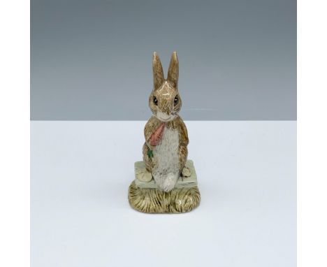 Glossy porcelain figure of a bunny sitting with a carrot in their mouth. Royal Albert Beatrix Potter backstamp. This item has