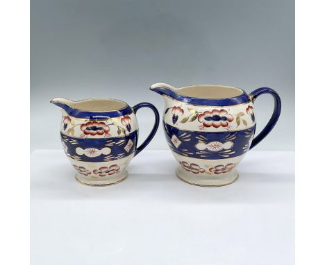 Large and medium sized blue, rust, and gold colored pitchers. The floral pattern is hand-painted. Numbered on the bottom 242 