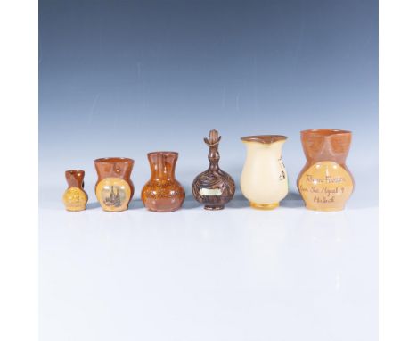 A set of six ceramic pitchers features four with varying sizes and a brown and orange glaze, each adorned with unique engravi