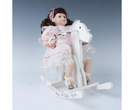 Adorable brown-haired girl in ruffled pink and lace dress sitting on her white rocking horse. Heritage Signature collection b