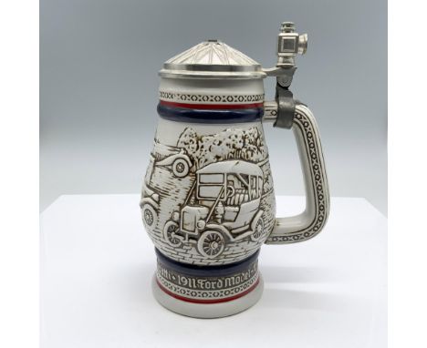 A ceramic drinking vessel with an attached metal lid with a highly raised design depicting images of antique cars: 1911 Ford 