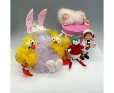 Lovely collection of decor that includes a fluffy Easter bunny with two baby chicks, a feathery figure on top of a pink stora