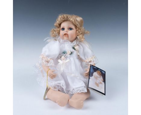 World famous artist designed doll with human hair eyelashes, hand painted face, dressed in hand sewn satin and lace clothing.