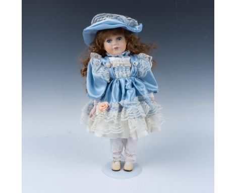 Hand crafted bisque porcelain doll with hand painted facial features offset by realistic eyelashes and long red curly hair. S