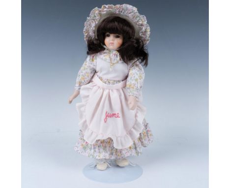 Handcrafted doll dressed in vintage floral dress with apron embroidered with the month and matching broad brimmed hat. Metal 