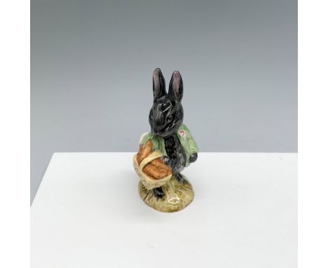 Glossy porcelain figure dressed in a green jacket and holding a basket of bread. Royal Albert Beatrix Potter backstamp. This 