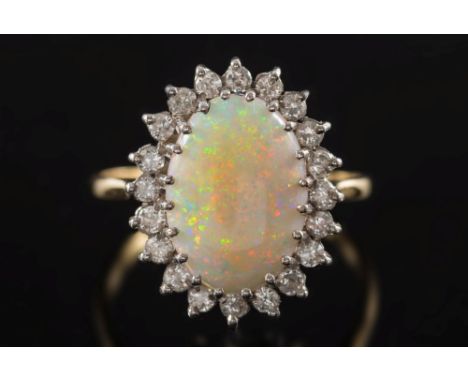 An opal and diamond cluster ring: with central oval opal claw-set within a surround of circular, brilliant-cut diamonds estim