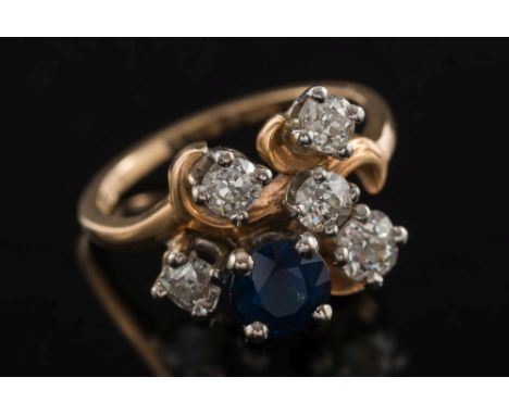 A sapphire and diamond mounted informal cluster ring: with single, circular sapphire amongst round old brilliant-cut diamonds