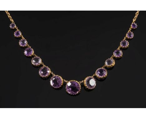 An amethyst mounted fringe necklace: with graduated, circular amethysts in cut-down collet settings. 