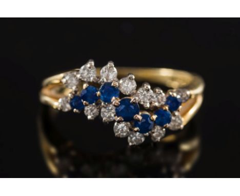 An 18ct gold, sapphire and diamond mounted informal cluster ring:, ring size P.  