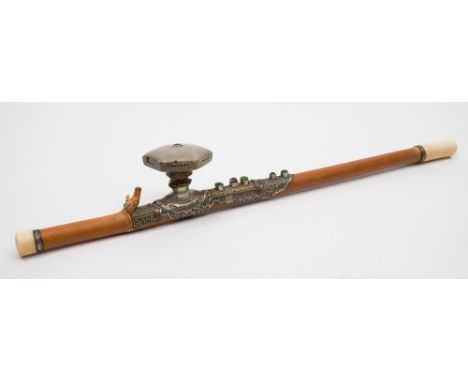 A Chinese bamboo opium pipe: with ivory end and mouthpiece, the white metal, copper and brass mount set with one faceted and 