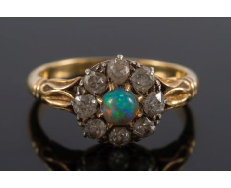 A gold, opal and diamond cluster ring: the central small circular opal approximately 4mm diameter claw-set within a surround 