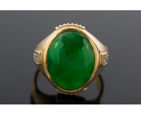 A gentleman's jade and diamond ring: with central oval green jade panel, approximately 16mm x 13mm, between diamond three-sto