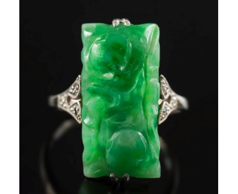 An early 20th century carved jade and diamond ring: with central rectangular jade panel between diamond-set shoulders, ring s