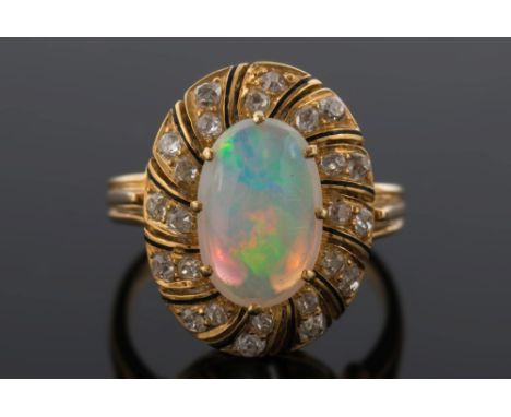 A gold, opal and diamond oval cluster ring: with central oval opal approximately 12mm x 8mm claw-set within a black enamelled