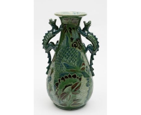 A C. H. Brannam (Barnstaple) pottery vase: of tear drop form with flaring neck and dragon handles, the body incised and appli