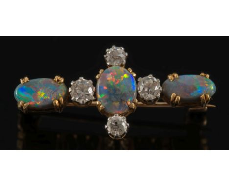 A gold, black opal and diamond bar brooch: with three oval black opals, highlighted with four round old brilliant-cut diamond