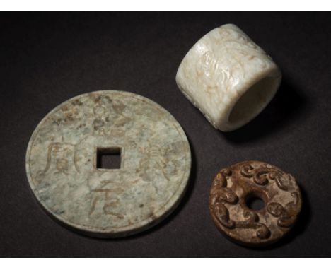 A Chinese jade archer's ring and two discs: the archer's ring carved with a four-character inscription and two deer, one hold