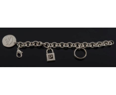 Tiffany & Co. A diamond mounted three-stone ring:, stamped 'Tiffany & Co', together with a similarly stamped circular pendant