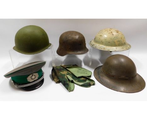 Five military helmets: East German Army Military police cap, an early 20thC. German steel helmet, a Zuckerman 1941 helmet wit