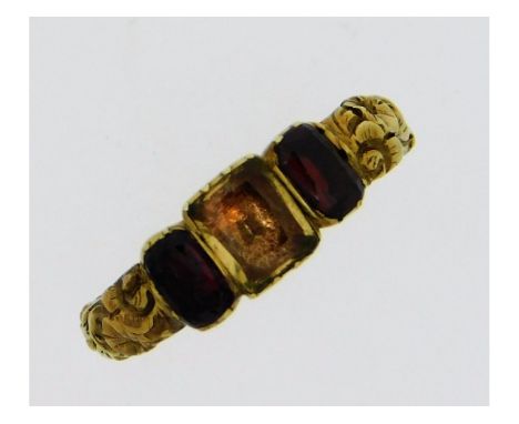 A Victorian yellow metal ring, electronically tests as 12ct gold, set with citrine &amp; garnet with carved floral decor, wit